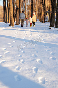 快乐家庭在雪地里散步
