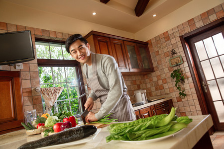 温馨做饭摄影照片_青年男人在厨房里做饭