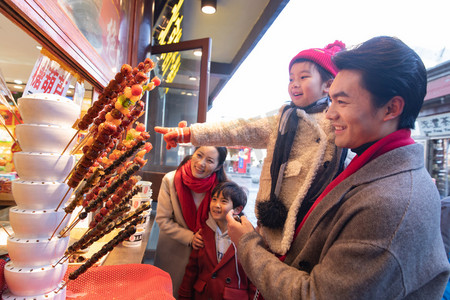 都市休闲摄影照片_快乐的一家人买糖葫芦