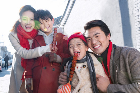 老北京糖葫芦摄影照片_快乐的一家人拿着糖葫芦逛街