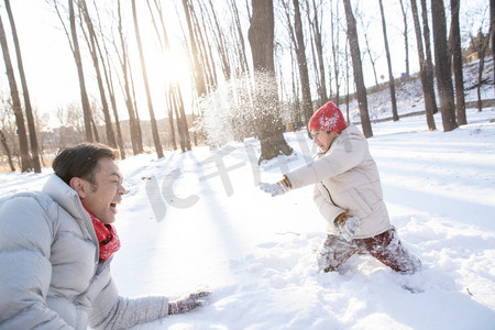 在雪地上玩耍的快乐父子