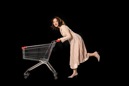 天猫电商节海报摄影照片_购物节女生推着购物车去购物摄影图配图