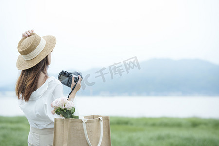 手拿相机的女子摄影图配图