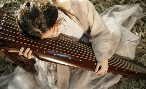 抱着古琴的古风女子摄影图配图