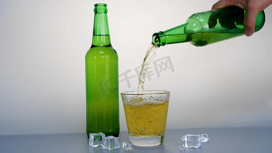男人倒大啤酒杯泡沫的啤酒实拍夏天倒酒倒啤酒冰镇啤酒加冰气泡酒男人