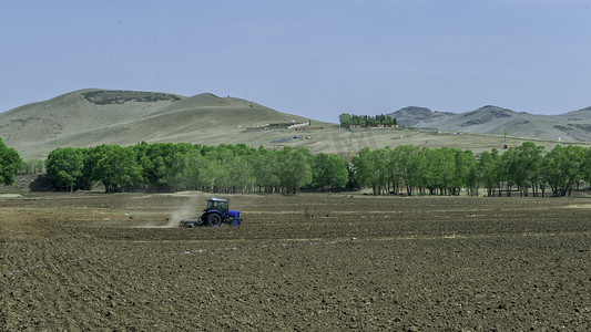 拖拉机背景图摄影照片_山村田地耕种上午田地耕种室外素材摄影图配图