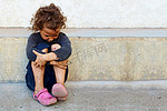 可怜的孩子小姑娘坐到混凝土墙