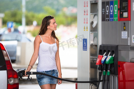 女人在加油站给她的车加油