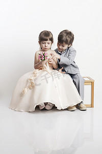 纵向的两个漂亮小男孩和女孩在婚礼礼服