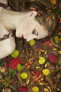 时尚的秋季花园里的美丽的年轻女子肖像