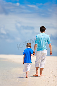 儿童泳摄影照片_父亲和儿子在海滩上