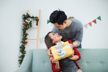 圣诞节对亚裔夫妇。一个英俊的男人，给她的女朋友/老婆