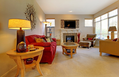 优雅的客厅与红色的沙发、 壁炉、 电视和许多 windows.