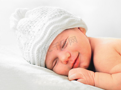 微笑着新生的婴儿的白帽子