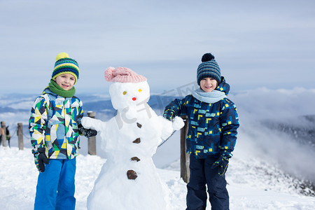 两个小孩，建在山顶的雪人