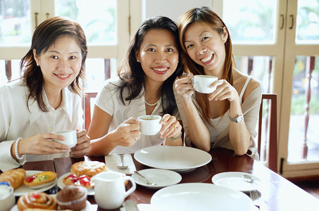 三个女人在咖啡馆，在相机微笑