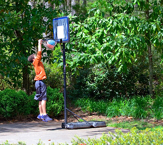 跳起来男孩摄影照片_年轻的篮球运动员