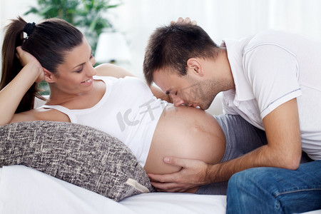 怀孕了摄影照片_未来爸爸亲吻他未出生的孩子