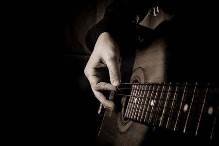 音乐宣传背景摄影照片_在黑色背景的吉他