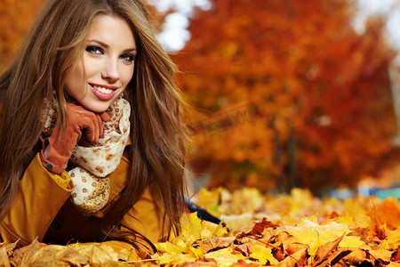 魅力女神季摄影照片_非常漂亮的年轻女人在秋天公园的肖像