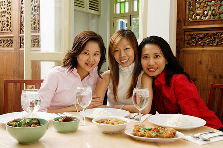 三个女人坐在餐馆的桌子
