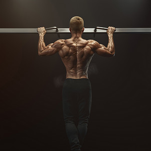 力量肌肉健美的家伙在健身房做俯卧撑。健康的男人