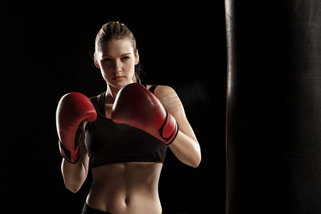 健身房运动卡摄影照片_美丽的女人是在黑色背景上拳击