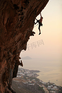 爬升摄影照片_攀岩在日落、 胡志明市岛、 希腊