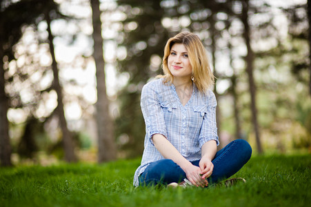 生活境界摄影照片_一个美丽的女人，坐在草地的肖像