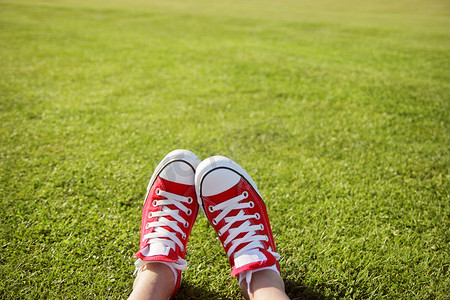脚踏在绿草里的运动鞋