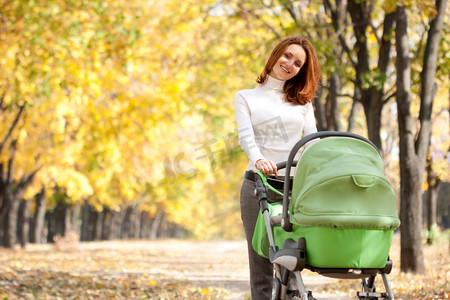 婴儿小推车摄影照片_快乐年轻的母亲和婴儿的越野车