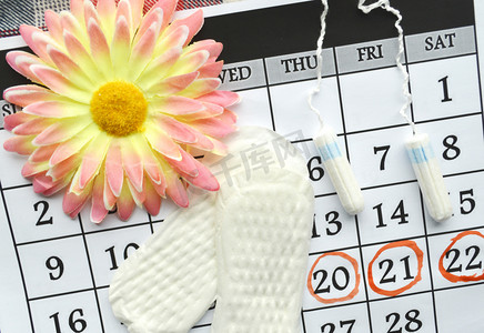女人卫生防护，关闭 up.menstruation 日历与棉花卫生棉条，橙色格柏，卫生护垫红色背景上