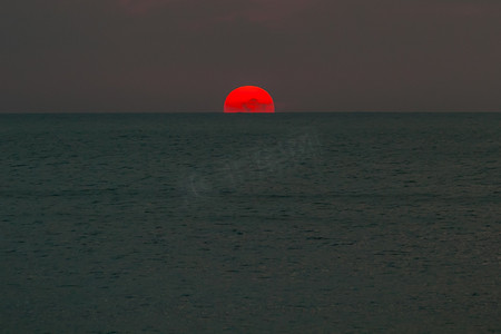 红色浪花背景摄影照片_海面上美丽的落日