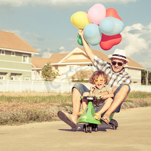 气球房子摄影照片_父亲和儿子在一天时间在房子附近玩耍