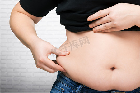 牛仔裤字体摄影照片_肥胖的肚子的女人