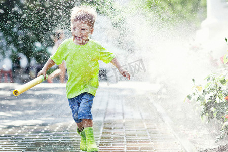 孩子和母亲穿着粉红色和绿色的雨靴