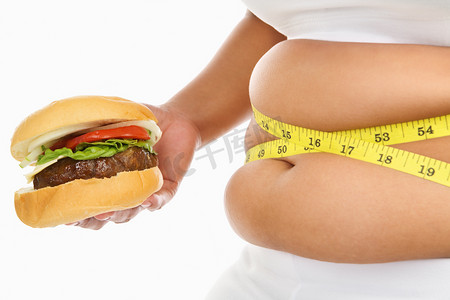 肚子大摄影照片_胖肚子周围有测量磁带和汉堡