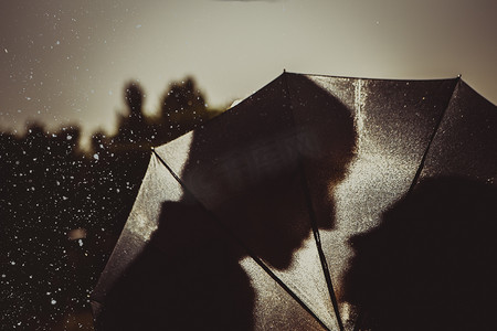 伞下的男孩摄影照片_雨中的爱情/雨伞下亲吻情侣的轮廓