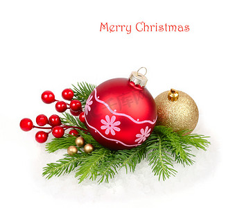 圣诞树枝摄影照片_在白色背景上的圣诞树枝上的红色和金色圣诞球。圣诞节背景以及放置文本的位置.