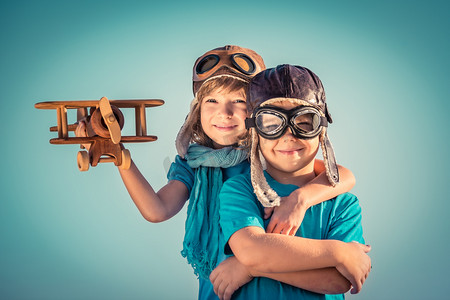 玩具行动摄影照片_快乐的孩子们玩的玩具飞机