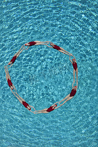 花样游泳摄影照片_同步的游泳者围成一个圆圈