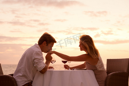 夫妇在海滩上享受浪漫 sunnset 晚餐