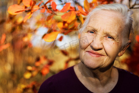 森林里走路摄影照片_秋季老人女人秋天
