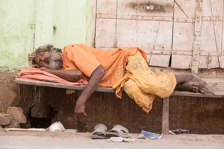 美德水黑摄影照片_印度无家可归的男人睡在神圣的美德湖沿山路附近