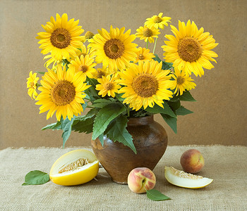 老师礼物摄影照片_向日葵和艺术背景上的水果静物