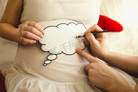 特写镜头的男子在妻子怀孕 abdom 登录上写的图片