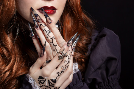 acrylic摄影照片_Beautiful long sharp black graft acrylic nails image for witches
