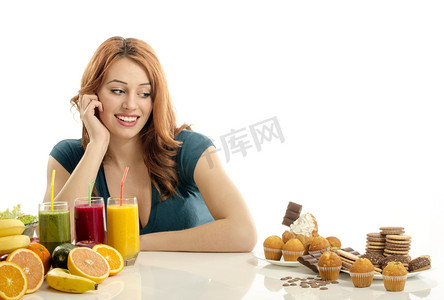 糖果吧摄影照片_女人选择水果、 思慕雪与反对糖果、 糖、 很多糖果，有机健康食品不健康的食物。治疗以水果和蔬菜你糖果成瘾