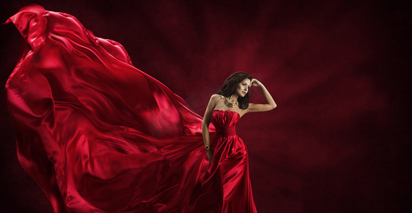红色丝绸创意摄影照片_红色的裙子，飞行时尚真丝织物的衣服，女人模型构成挥舞着布