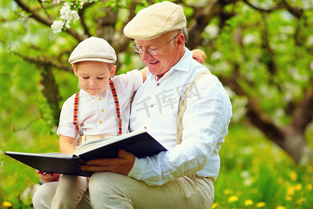 春天spring摄影照片_祖父与孙子读书在春天的花园